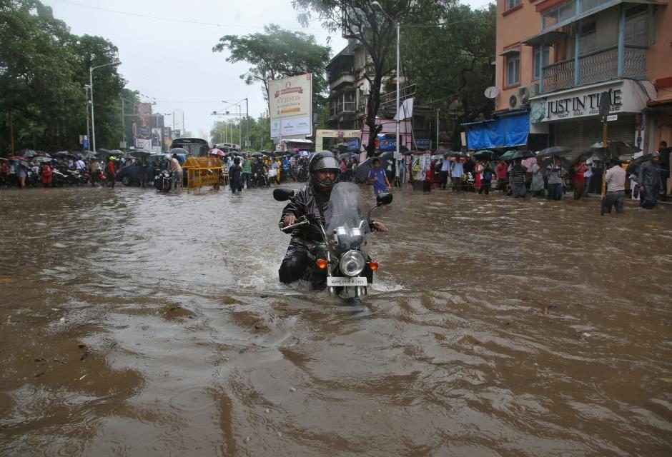 Click to enlarge A man rides his motorbike through a water-logged road during rains in Mumbai, India, August 29, 2017.