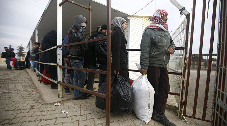 Syrians line up as they wait to cross into Syria at Oncupinar border crossing in the southeastern city of Kilis