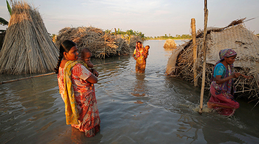 Click to enlarge women carry children Bangladesh floods