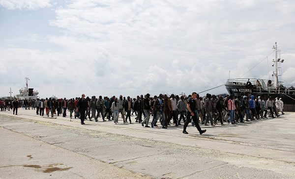 Migrants disembark from the Italian Navy vessel