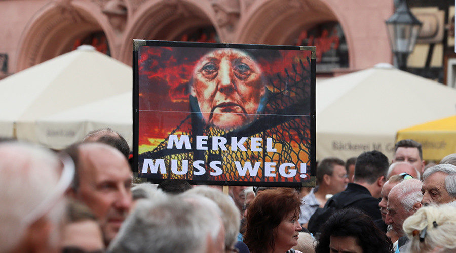 Protesters hold a sign reading 