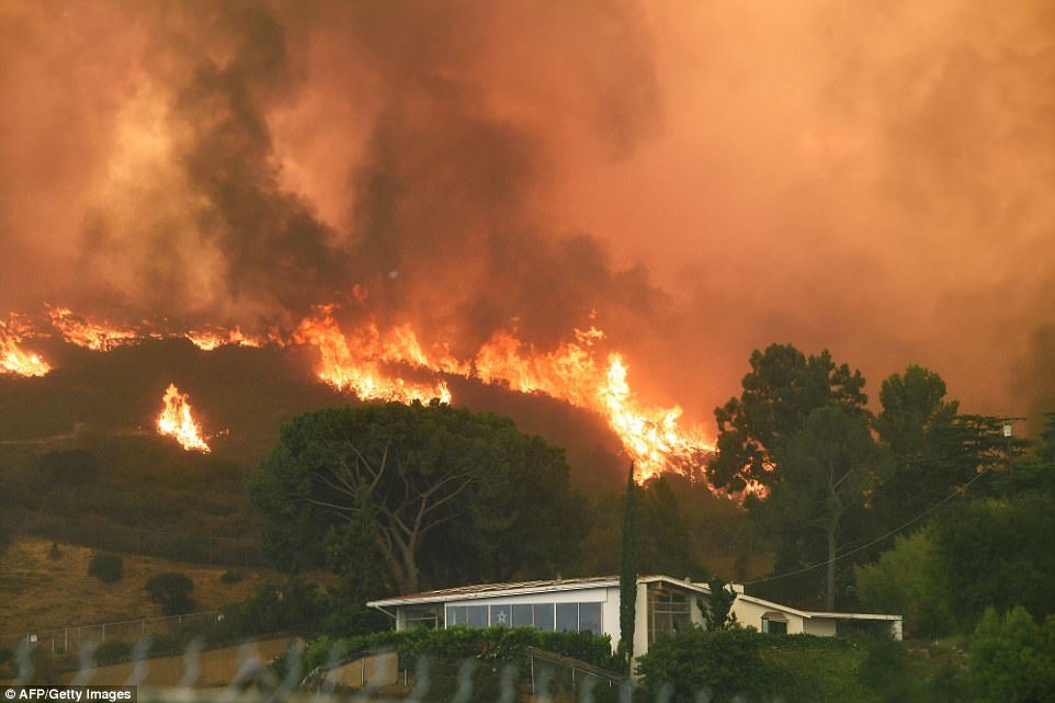 Click to enlarge Flames from the La Tuna Fire blaze on a hill in the Shadow Hills on Saturday come dangerously close to this home in the foreground
