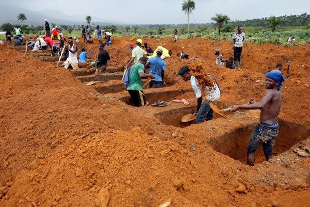 Workers are seen digging graves at Paloko cemetery in Waterloo, Sierra Leone