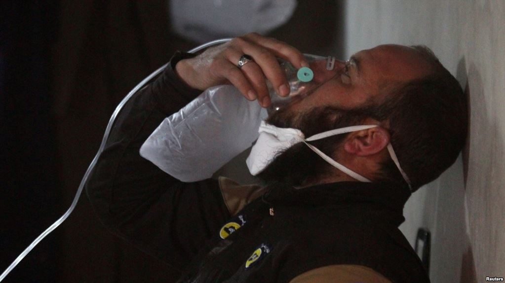 civil-defense member breathes through an oxygen mask