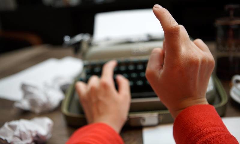 Click to enlarge person typing writers