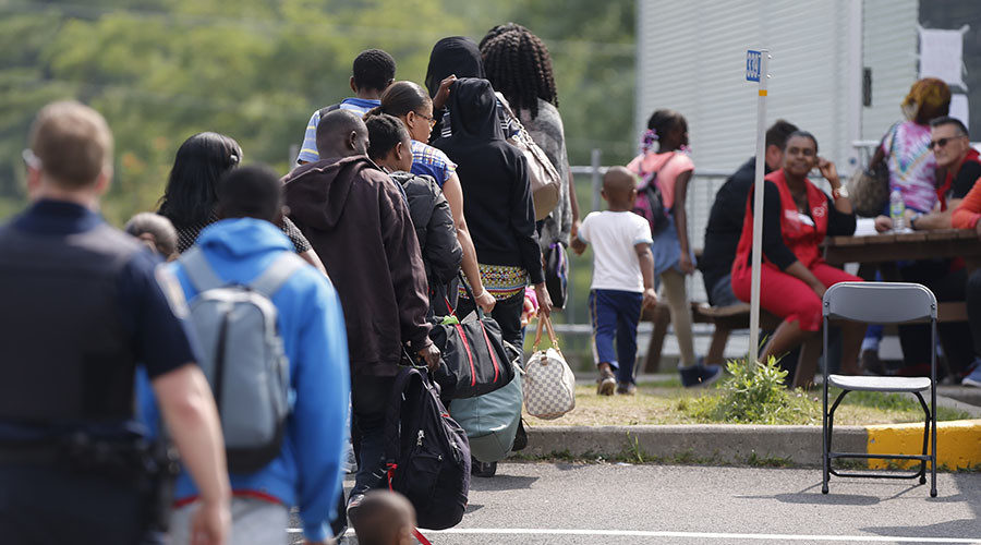 group of asylum seekers wait to be processed