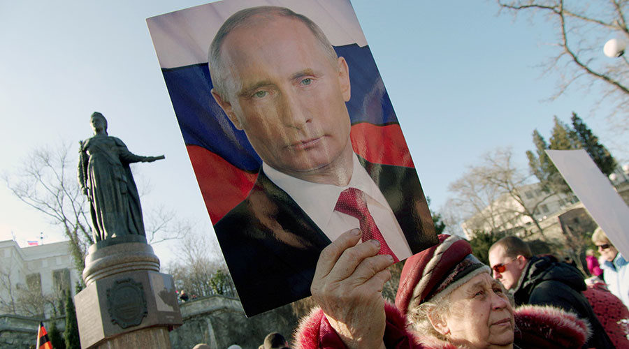 Woman holding portrait of Vladimir Putin