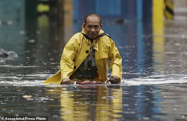 A man pedals his bicycle along a flooded street in Manila, Philippines on Tuesday, Sept. 12, 2017.
