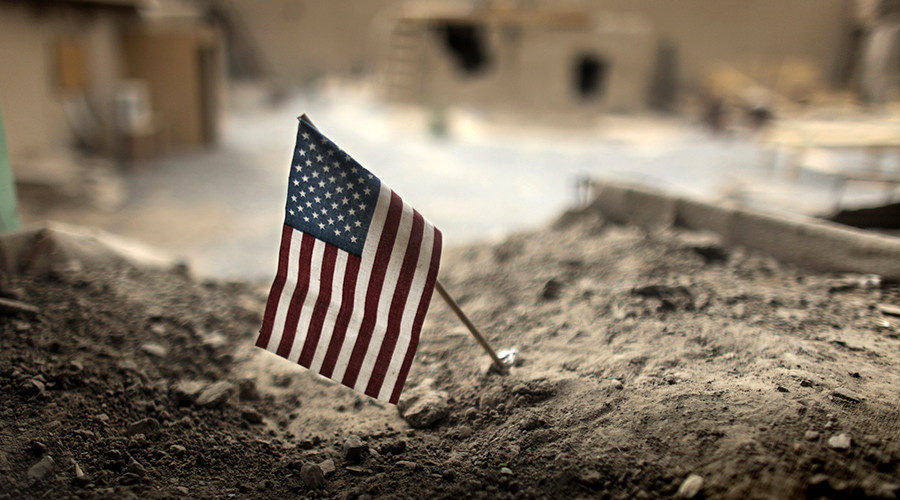 An American flag is placed in a dirt-filled barrier, at Combat Outpost Nolen, north of Kandahar