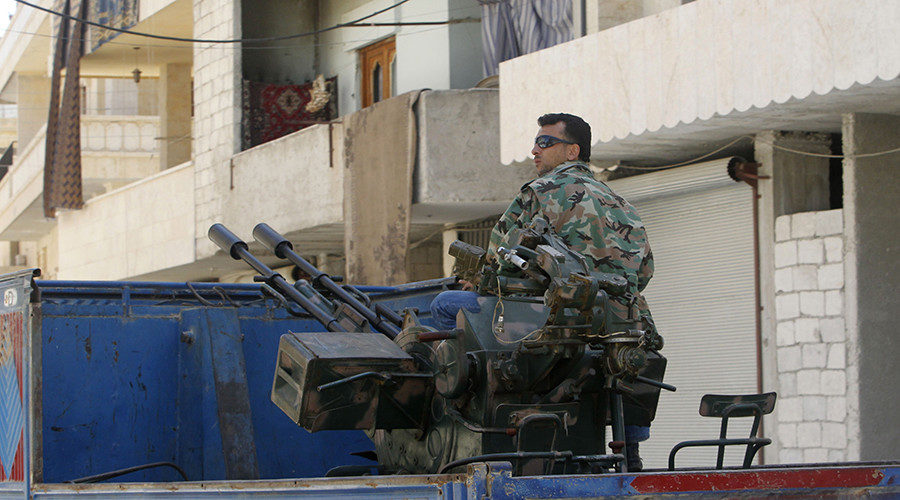 A Free Syrian Army fighter sits on a pick-up truck mounted with anti-aircraft weapon