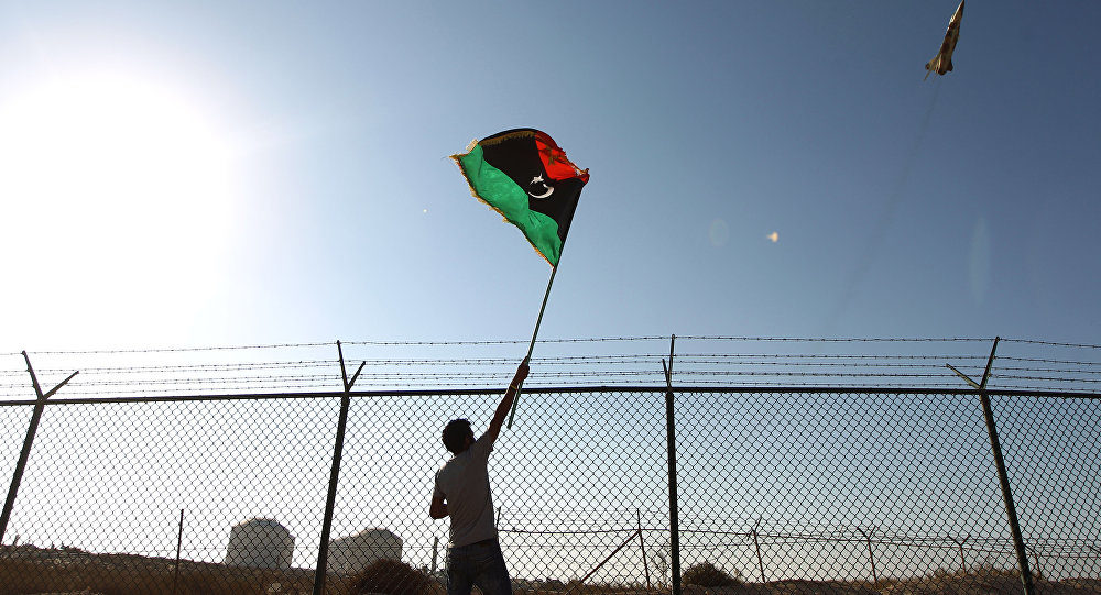 Click to enlarge A man waves a Libyan flag