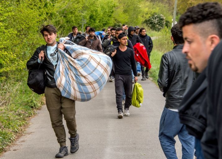 Click to enlarge Migrants carry belongings