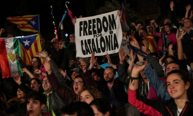 People react as they gather at Plaza Catalunya after voting ended