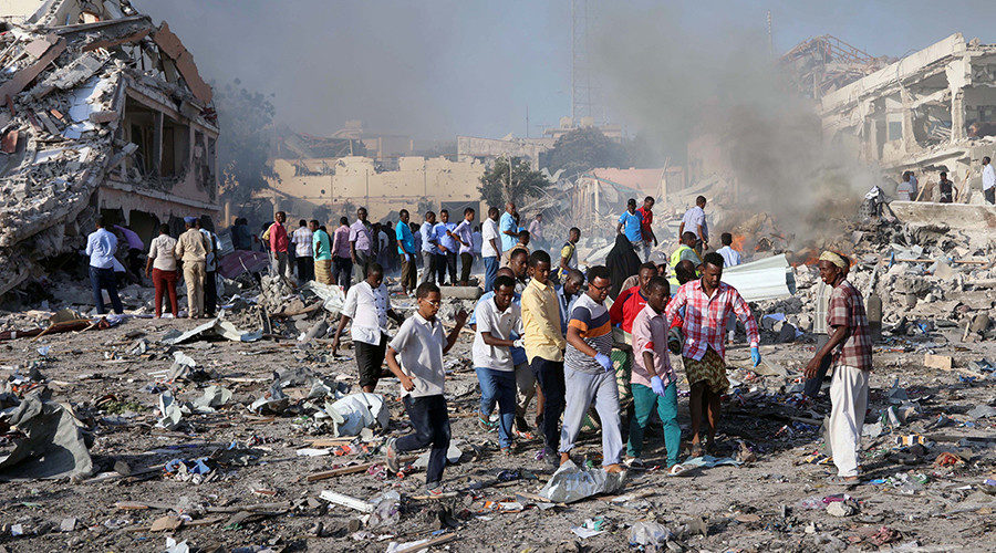 Civilians carry the dead body of an unidentified man from the scene of an explosion in KM4 street in the Hodan district of Mogadishu