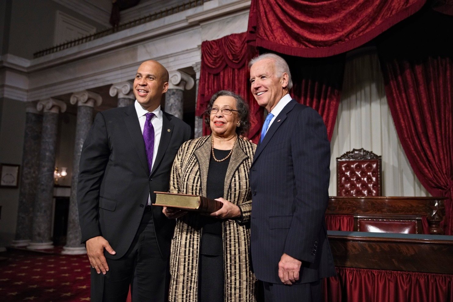 Sen. Cory Booker (D-N.J.), left, poses with his mother, Carolyn Booker, and then-Vice President Biden at a Senate swearing-in ceremony at the Capitol on Oct. 31, 2013.