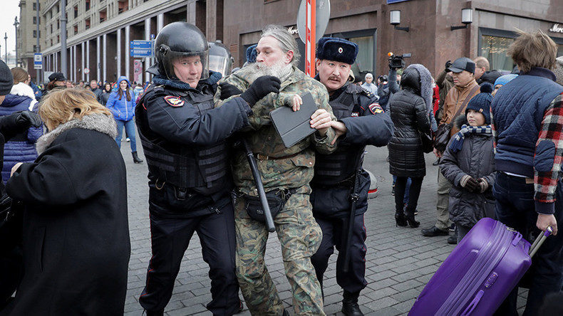 Police officers detain a man