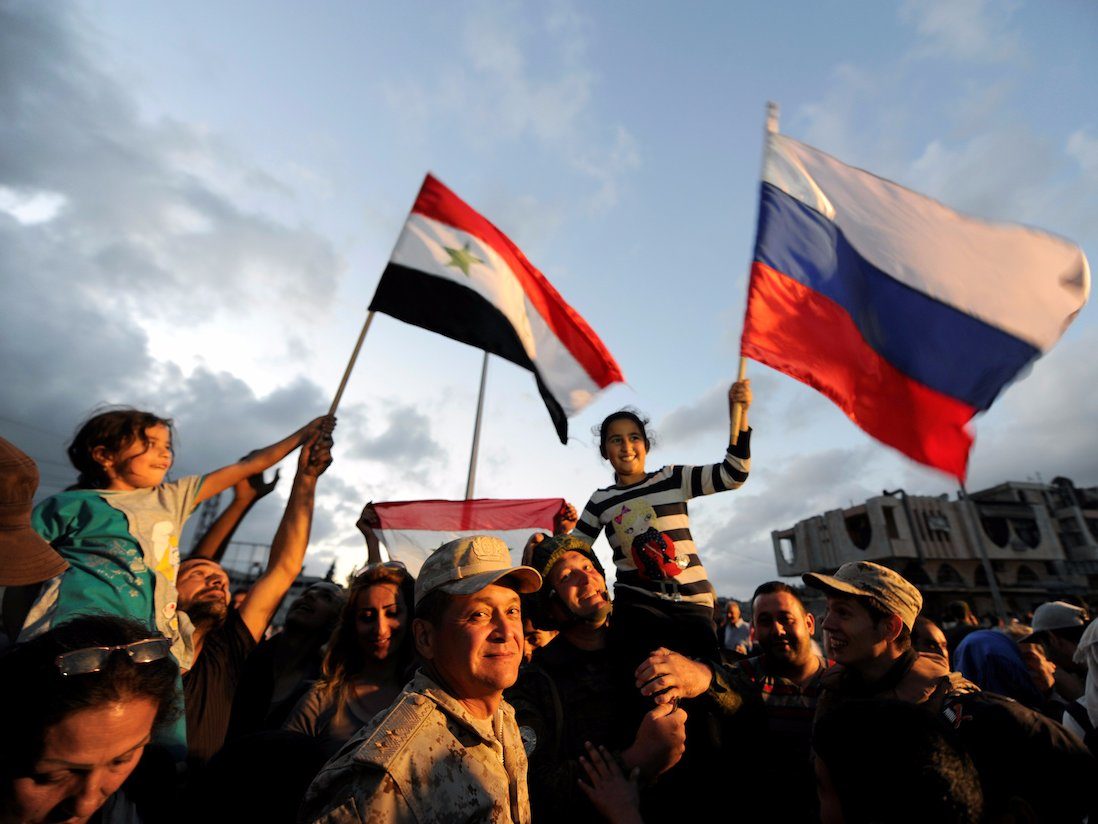 Click to enlarge People celebrate with Russian and Syrian flags inside Waer district, after rebel fighters and their families evacuated the besieged Waer district in the central Syrian city of Homs, May 21, 2017 Reuters