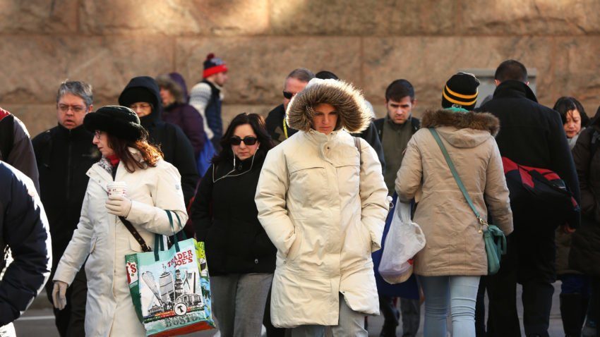 People are in varying stages of bundle outside South Station.