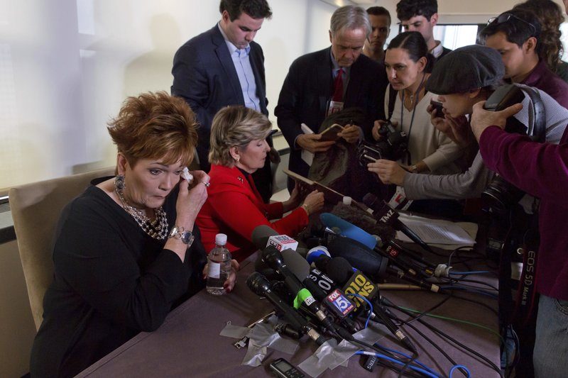 Beverly Young Nelson, left, the latest accuser of Alabama Republican Roy Moore, wipes her eye as attorney Gloria Allred