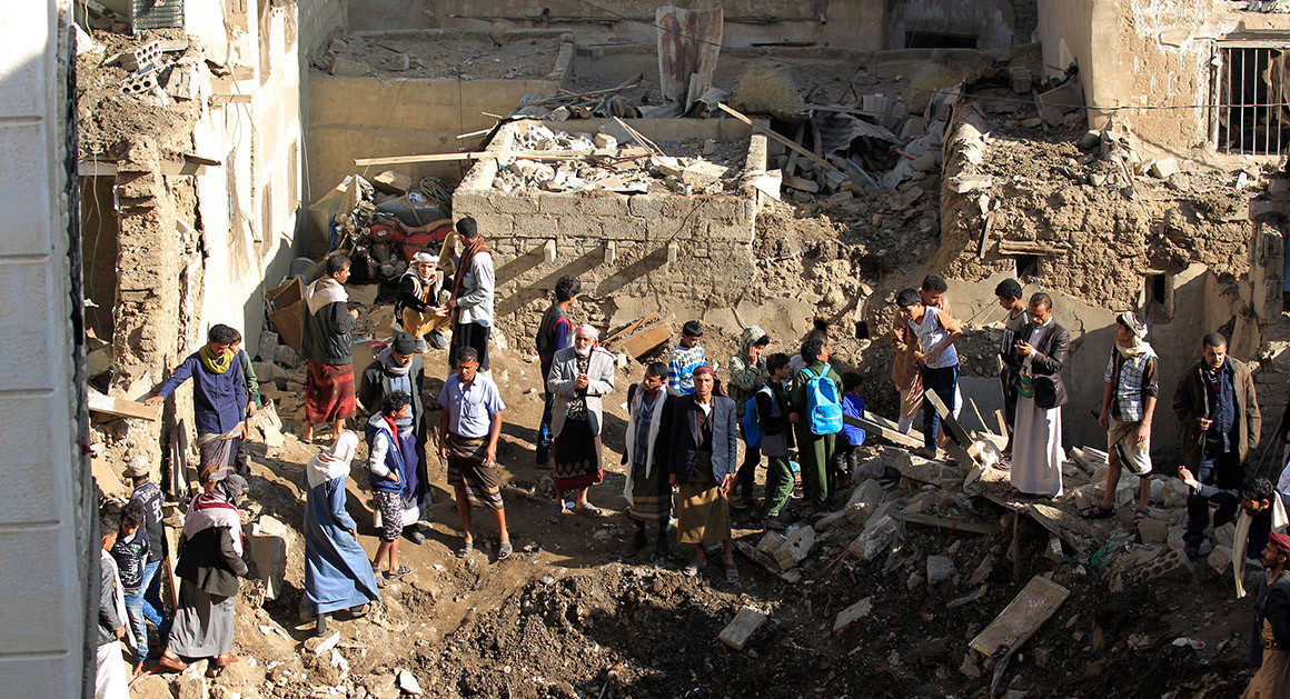 People look at the damage in the aftermath of an air strike in the Yemeni capital of Sanaa on Nov. 11