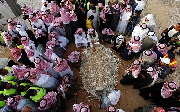 Click to enlarge Mourners gather around the grave of Saudi King Abdullah following his burial in Riyadh