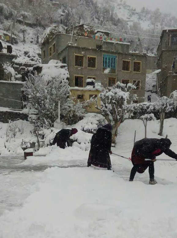 Villagers remove snow from near their houses in Lahaul and Spiti district on Friday