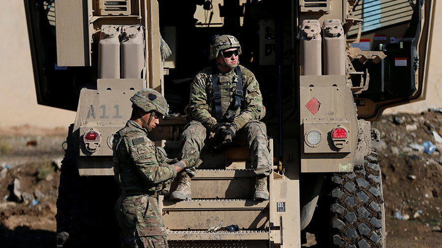 US army soldiers sit next a military vehicle in the town of Bartella, east of Mosul, Iraq, December 27, 2016.
