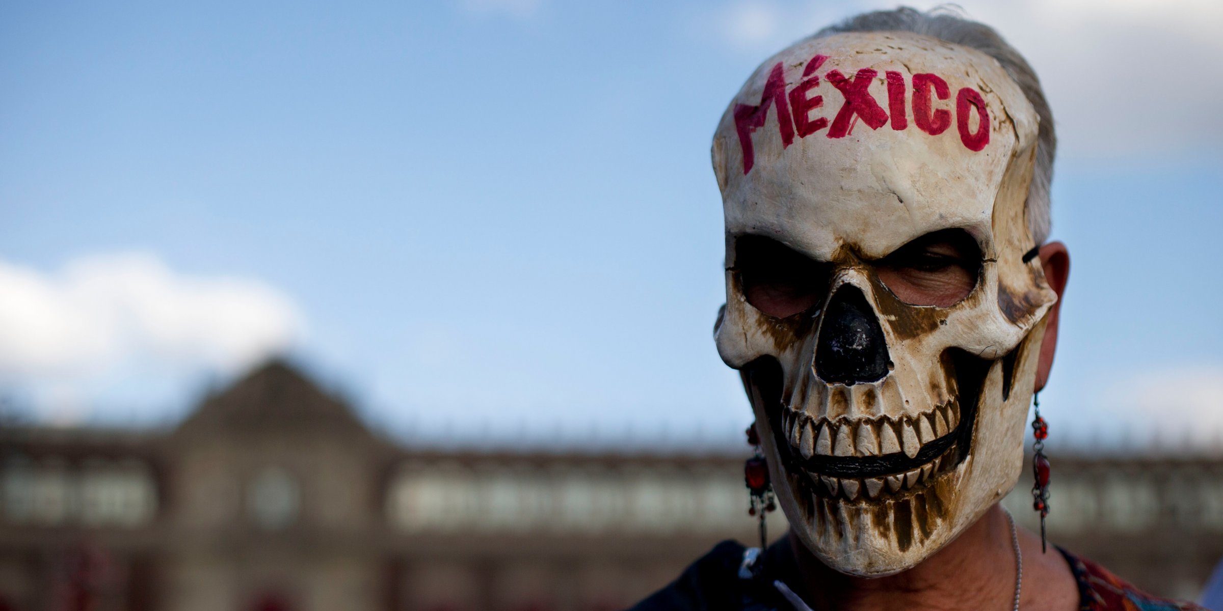 A woman wears a skull mask at National Palace Mexico