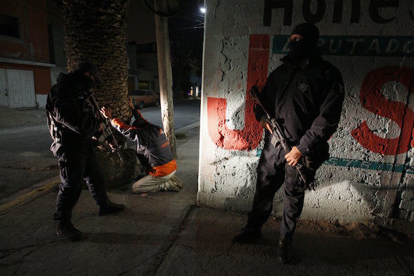Federal police search men for drugs and weapons during an antinarcotics operation in Ecatepec