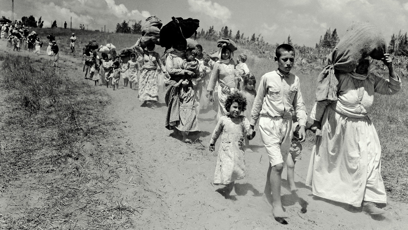 Click to enlarge Palestinian refugees flee a village near Haifa, in June, 1948, during the 1948 war.