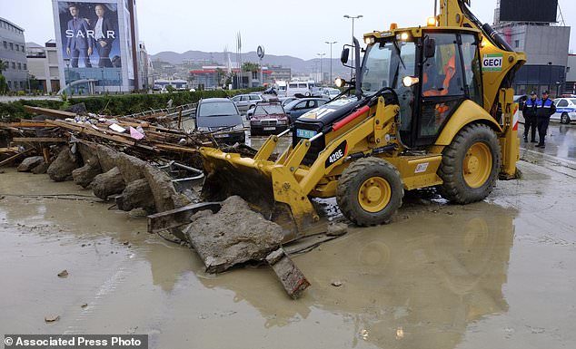 A bulldozer cleans a highway from debris after heavy rainfalls in Tirana, Friday, Dec. 1, 2017.