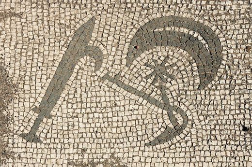 A mosaic with a sword, a moon crescent, Hesperos/Phosphoros, and a pruning knife that was found within a second-century Mithraeum.