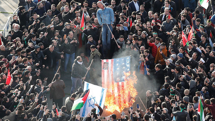 Demonstrators set U.S. and Israeli flags on fire during a protest against U.S. President Donald