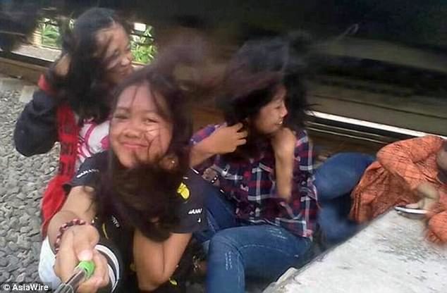 Shocking: This image shows the moment after Ely Hayati was hit by the train, her friend have yet to realise that she is injured