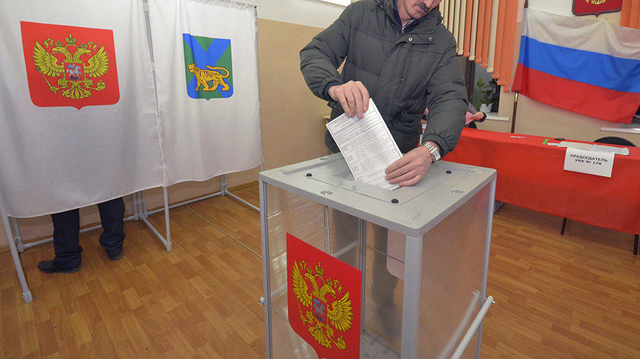 Click to enlarge A man casts his ballot during presidential elections at a polling station in the far eastern city of Vladivostok, Russia