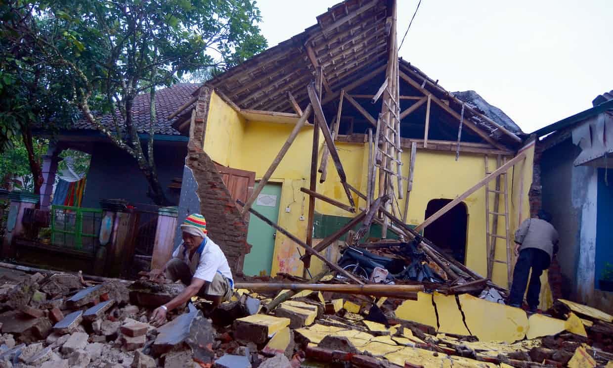 People inspect the ruins of a house in Tasikmalaya in West Java after an earthquake