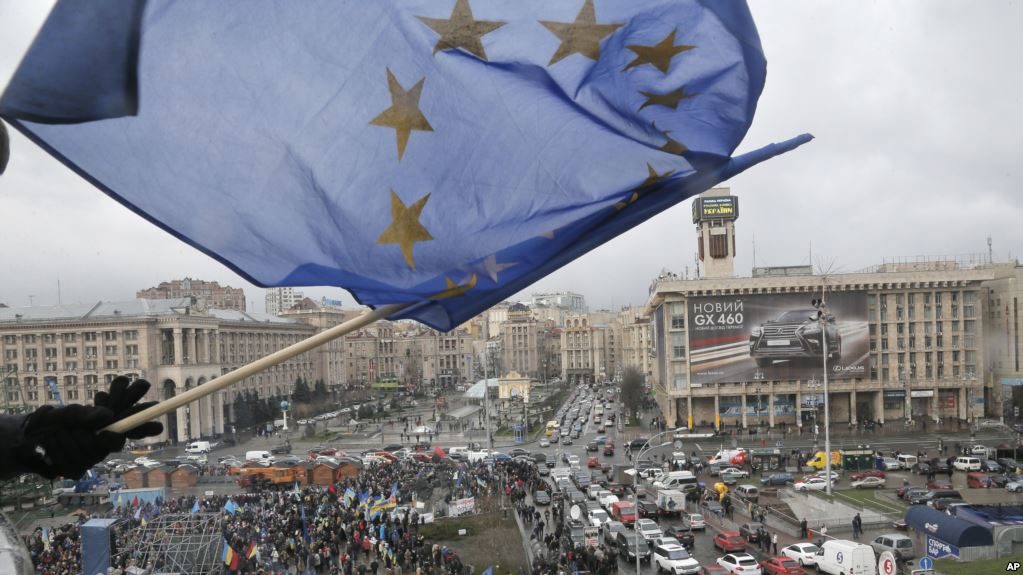 supporter waves European Union flag from a building top in Kyiv, Ukraine Nov. 29, 2013.