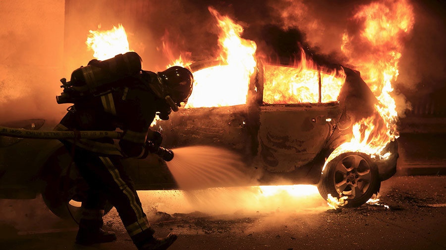 FILE PHOTO: Firefighters extinguish a burning car during New Year celebrations in Lille, northern France, December 31, 2015. x