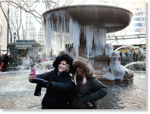 Women take a selfie in front of a frozen fountain in Bryant Park, Manhattan