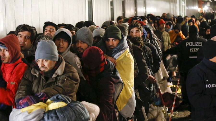 Migrants queue on a street to enter the compound outside the Berlin Office of Health and Social Affairs (LAGESO) for their registration process in Berlin.