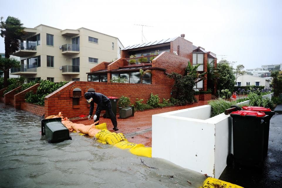 A resident piles sandbags to prevent flooding on the waterfront on in Auckland, New Zealand, on January 5.