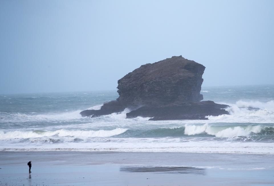 A man walks the beach in front of rough seas caused by Storm Eleanor in Portreath, in Cornwall, England, on January 3.