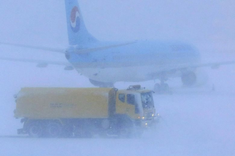 A snowplough clearing snow on a runway at Jeju International Airport, after the island was hit with heavy snowfall, on Jan 11, 2018.