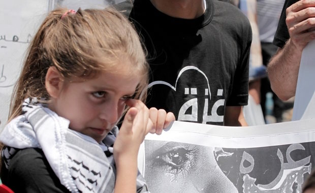 Palestinian girl holds a placard