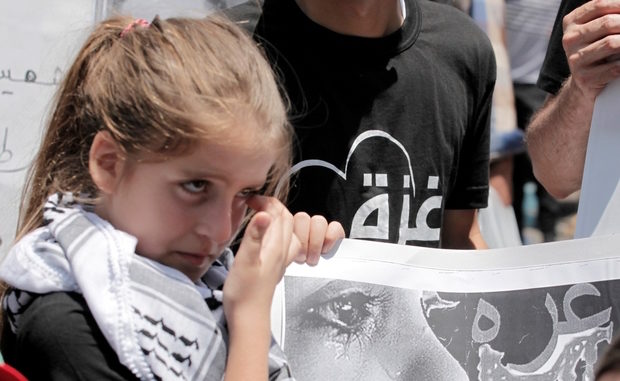 Click to enlarge Palestinian girl holds a placard