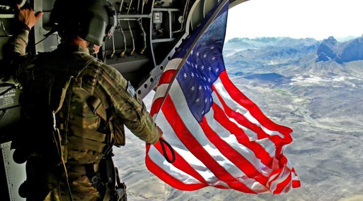 US soldier waving US flag over Afghanistan