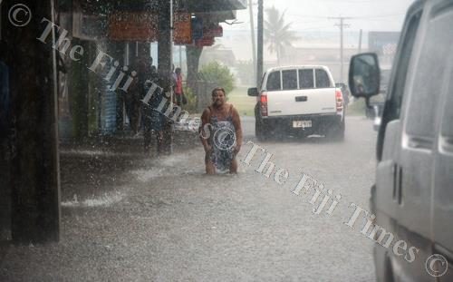 A woman is seen wading in the flooded Vitogo Pde in Lautoka City yesterday.