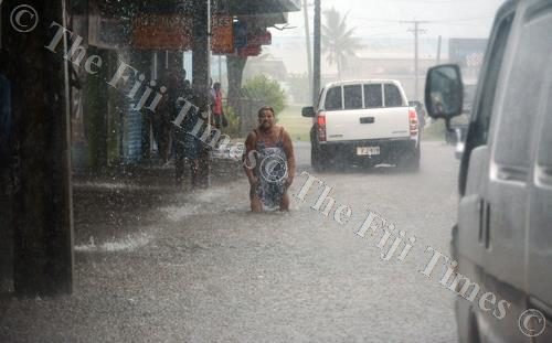 Click to enlarge A woman is seen wading in the flooded Vitogo Pde in Lautoka City yesterday.