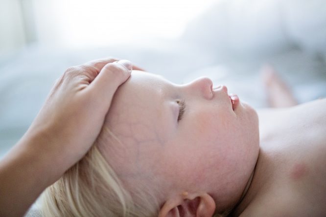 ill child hand forehead