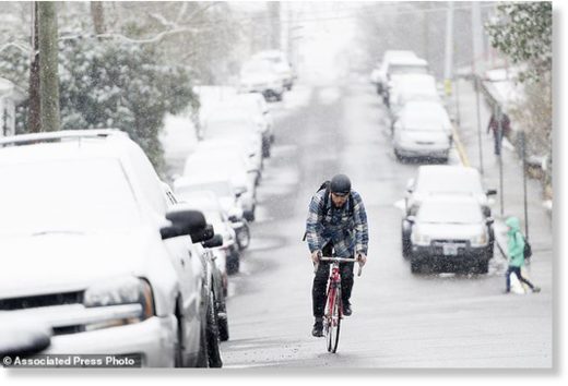 UT senior Marlow Payat, of Memphis, bikes along Laurel Ave during an afternoon snowfall in Knoxville, Tenn., on Tuesday, Jan. 16, 2018.